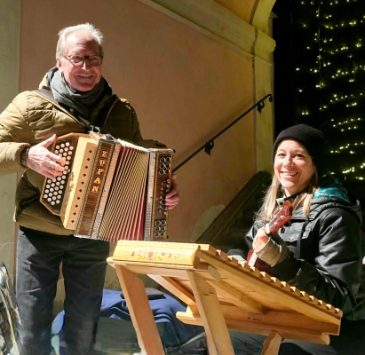 Maik und Julia laden zum gemeinsamen Adventlieder-Singen am Haller Adventmarkt ein.