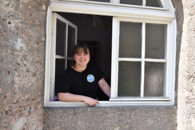 Frau schaut aus einem Fenster.
