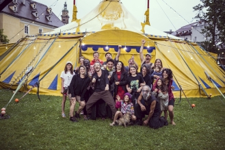 Künstlergruppe vor großem Zirkuszelt