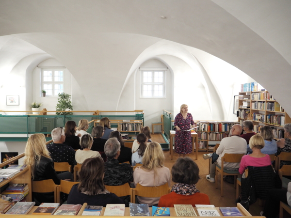 das Publikum sitzt vor der Autorin und hört ihr beim Vorlesen zu.